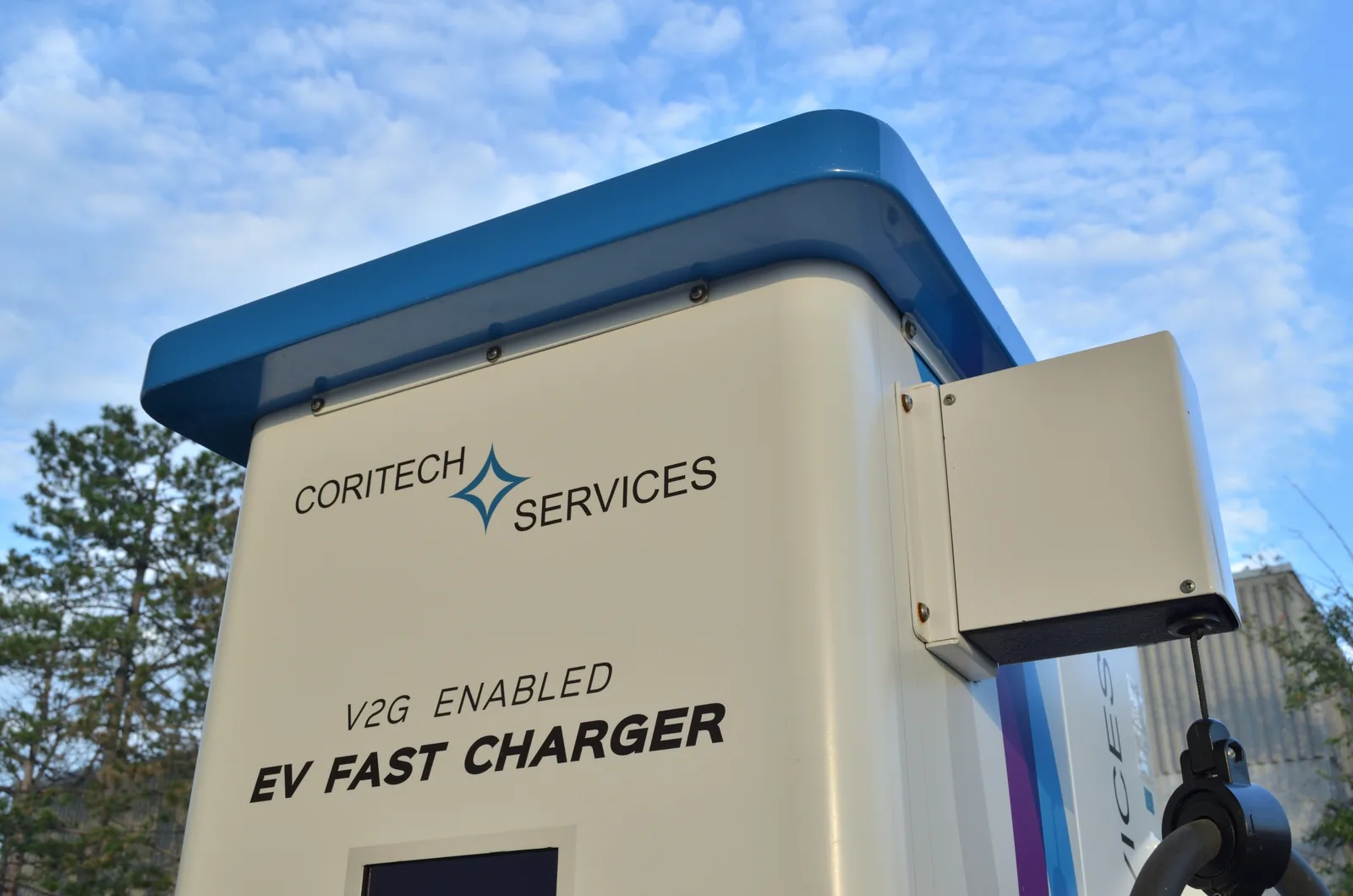 Close-up of a Coritech Services charger labelled “V2G Enabled EV Fast Charger”.