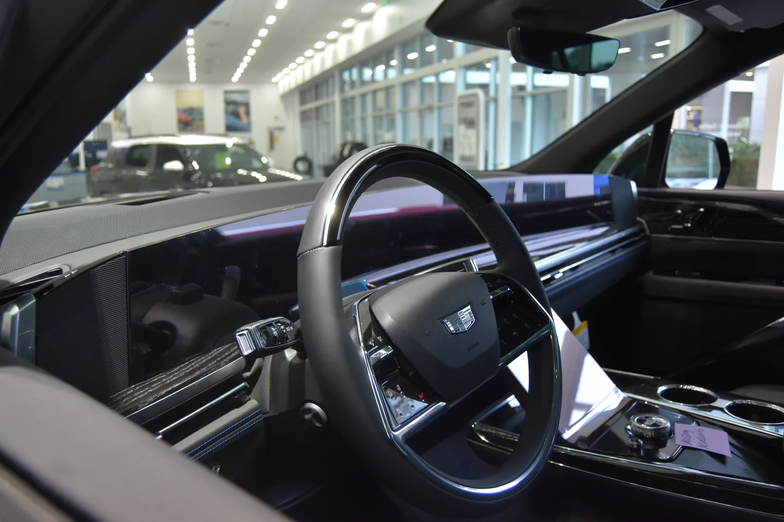 Interior of a 2025 Cadillac Escalade IQ, showing its steering wheel and panoramic display.