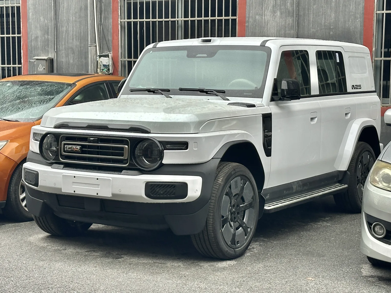 White V25 photographed while parked, with round headlights, an iCar grille badge and a visible V25 badge beside the rear window.