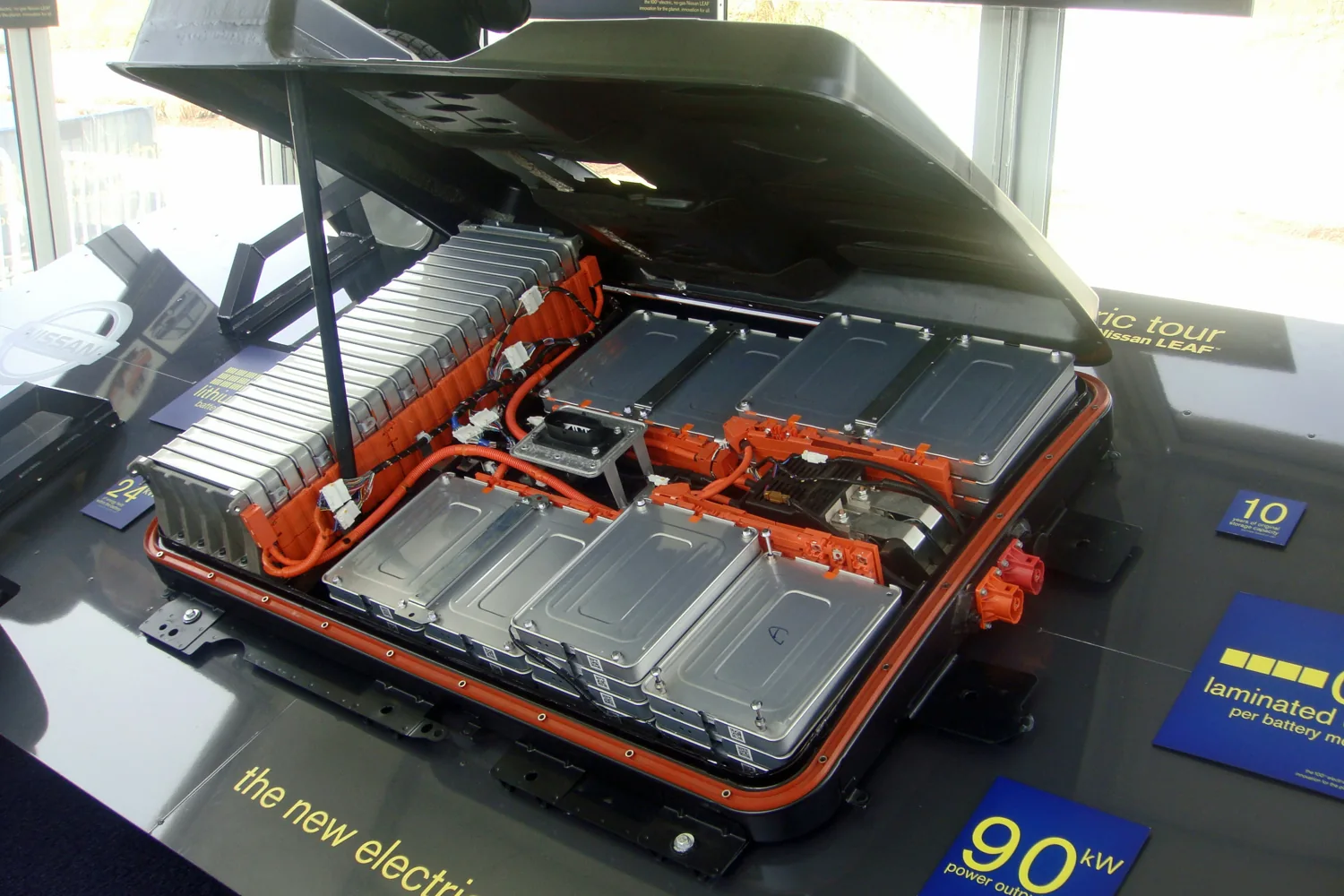 Opened Nissan Leaf battery pack on display, with modules and high-voltage connections visible.
